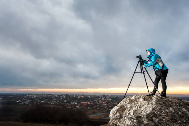 Fotografo donna con macchina fotografica su treppiede sulla grande roccia
 - Foto, immagini