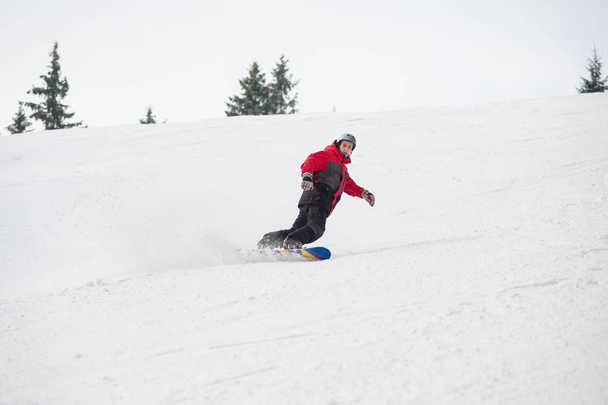 Hombre snowboarder montar desde la montaña en el día de invierno
 - Foto, Imagen