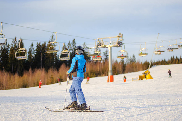 Skifahrerin an sonnigem Tag gegen Skilift und Wald - Foto, Bild