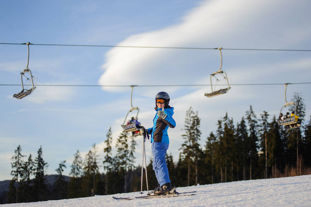 Sciatrice contro skilift e bosco in una giornata di sole
 - Foto, immagini