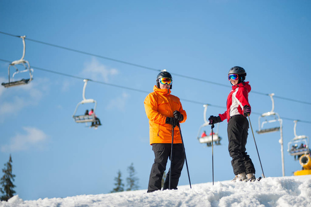 Hombre y mujer esquiadores con esquís en estación de invierno
 - Foto, Imagen