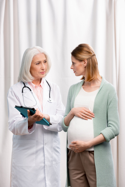 doctor talking with young pregnant woman - Photo, image
