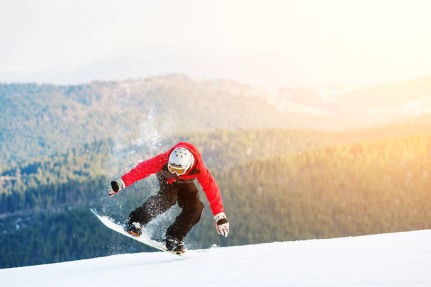 Male boarder on his snowboard at winer resort - Photo, image