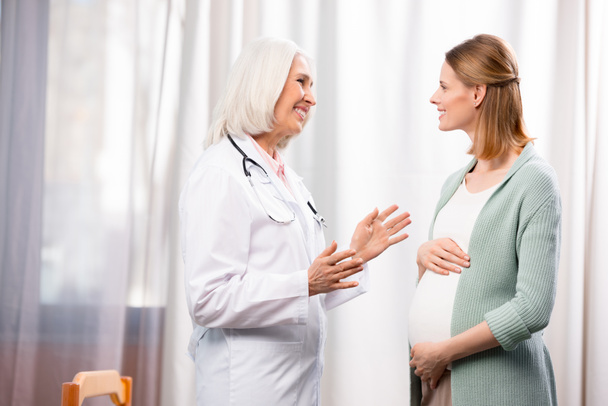 pregnant woman talking with doctor - Fotoğraf, Görsel
