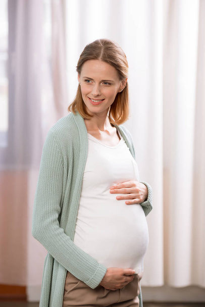 Fiatal mosolygó terhes nő - Fotó, kép