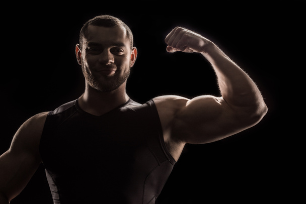 mladý kulturista protahuje biceps - Fotografie, Obrázek