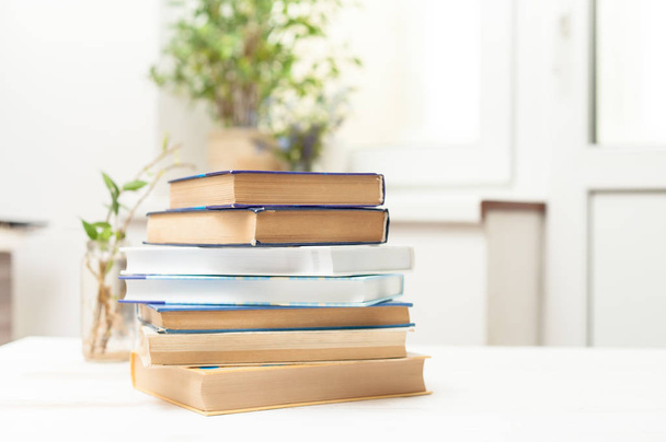 A stack of books on a white table - Foto, afbeelding