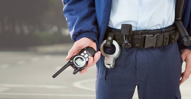 Security guard lower body with walkie talkie against blurry street - Φωτογραφία, εικόνα