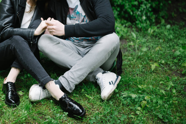piernas de pareja que se sientan en el parque
 - Foto, Imagen