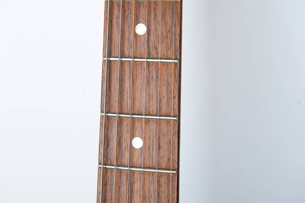 Cuello de guitarra con cuerdas sobre fondo blanco, espacio libre para el diseño
 - Foto, Imagen