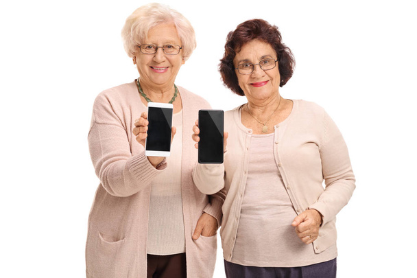 Ώριμες γυναίκες, δείχνοντας τηλέφωνα στην κάμερα - Φωτογραφία, εικόνα