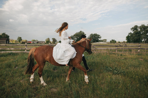 man walk with girl riding horse - Фото, изображение