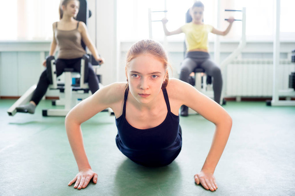 Girl doing exercises in gym - 写真・画像