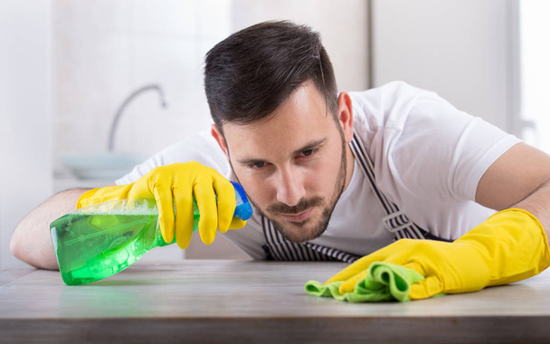 Man wiping kitchen table - Photo, Image