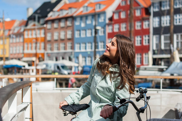 Mujer en bicicleta admirando los hermosos edificios antiguos de colores
 - Foto, Imagen