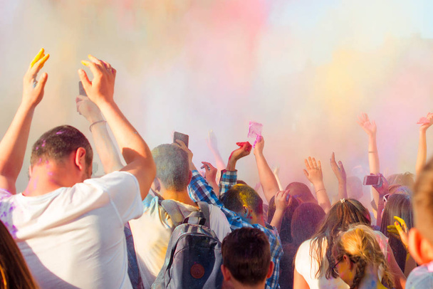 Молодые люди веселятся во время Holifest, бросая разноцветный порошок в воздух
 - Фото, изображение