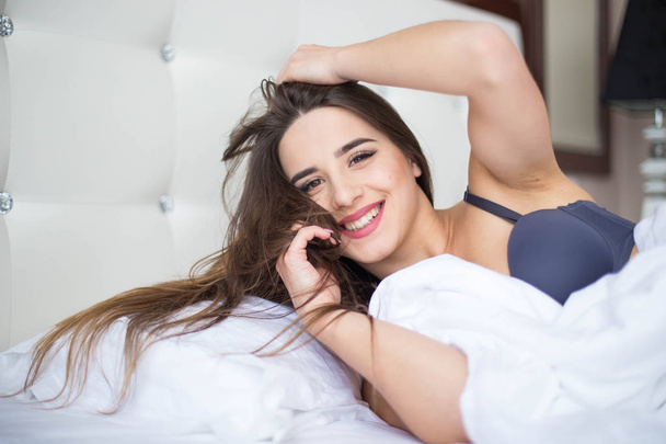 Kadın ev beyaz yatakta yatan güzellik gülümseme ile - Fotoğraf, Görsel