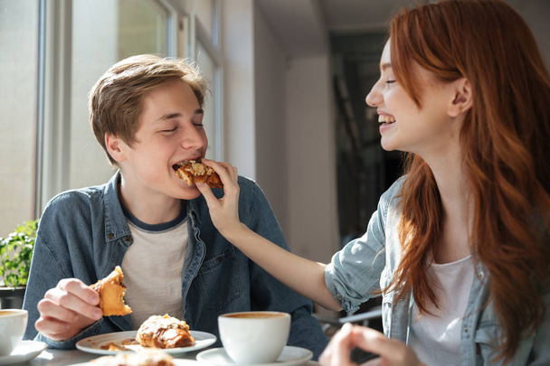 Tyttö opiskelija ruokkia poikaystävänsä
 - Valokuva, kuva