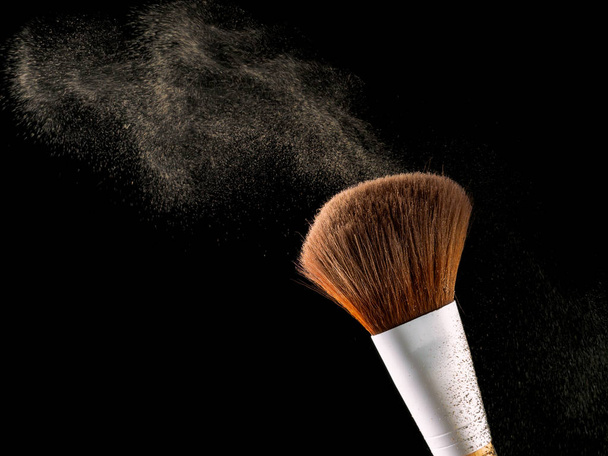 Cosmetic makeup brushes on  black background flash explosion splash powder shadow blush. - Zdjęcie, obraz