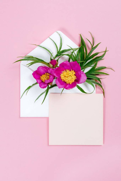 Colorful summer flowers in envelope and pink sheet on pink background. - Photo, Image