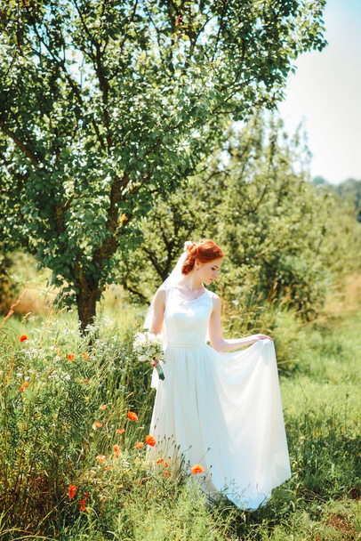 Young beautiful blonde woman in blooming garden. Bride. - Valokuva, kuva