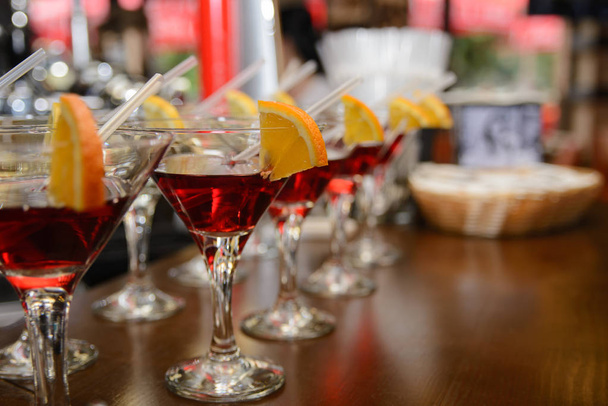 cocktail rouge avec citron et orange debout sur une table dans le bar
 - Photo, image