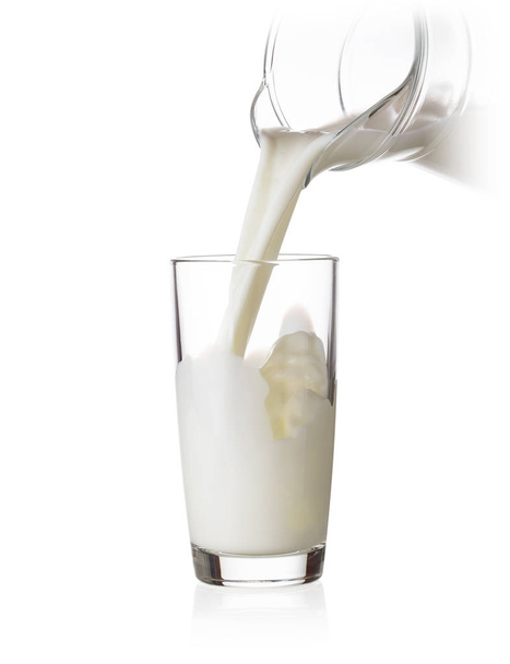 Vaso relleno de leche de una jarra
 - Foto, imagen
