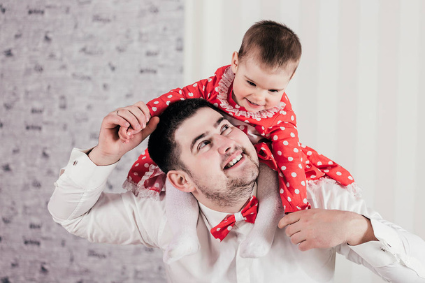 Der Mann verbringt munter Zeit mit der kleinen Tochter. Charmantes Baby sitzt auf Schultern beim Vater und lacht fröhlich. - Foto, Bild