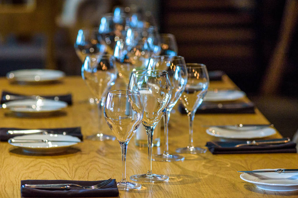 Beyaz masa örtüsü ile servis edilen boş restoran masası. - Fotoğraf, Görsel