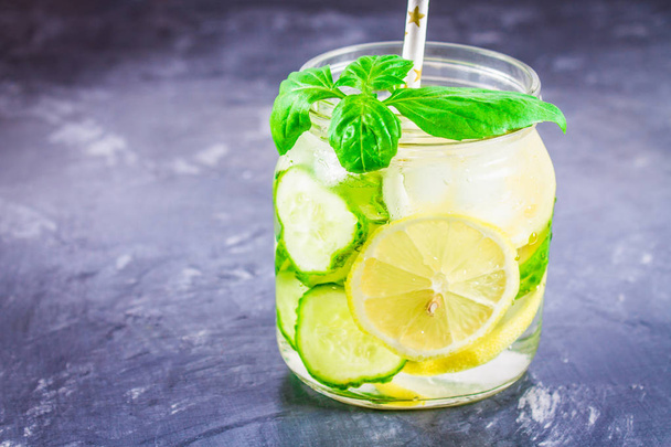 Sassy diet water. Cucumber, lemon, mint lemonade in glasses on grey background. - Foto, immagini