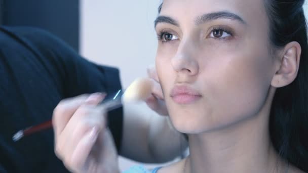 Makeup artist apply makeup to an attractive young women.  - Záběry, video