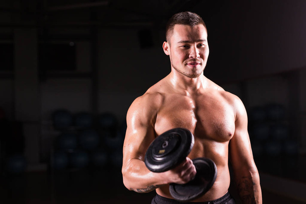 Erős egészséges jóképű sportos férfi Fitness modell jelentenek egy súlyzó portréja. - Fotó, kép