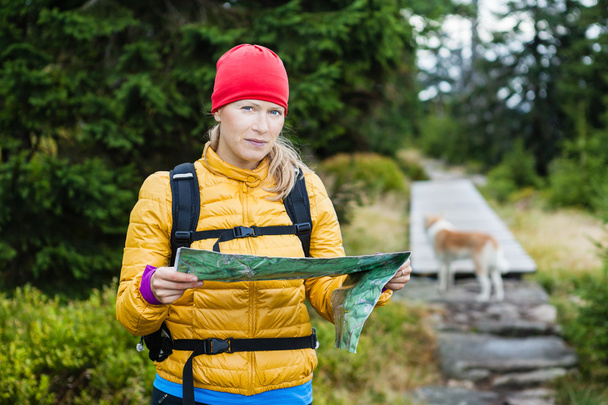 Donna escursionismo e lettura mappa nella foresta
 - Foto, immagini