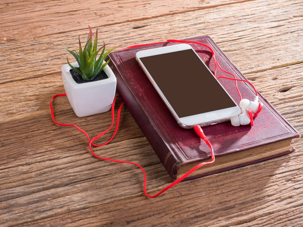inteligentny telefon i uszy wtyczkę na podłoże drewniane - Zdjęcie, obraz