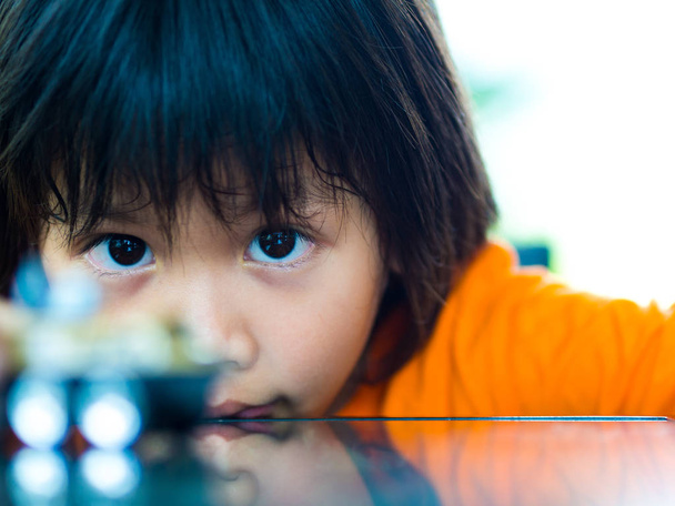 Nahaufnahme Porträt eines Kindes Blick auf sein Spielzeug - Foto, Bild