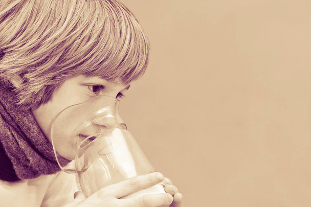 Pieni poika tekee hengitettävää kotona, ottaen lääkitystä keuhkoputkiin. putki
. - Valokuva, kuva