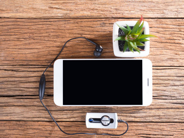 smart phone e tappi per le orecchie su sfondo in legno
 - Foto, immagini