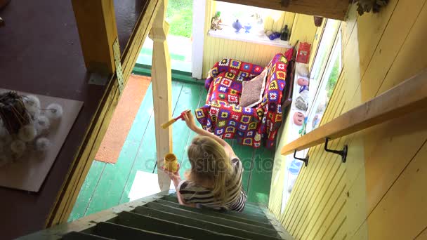 merdiven ve sarı renk fırça ile boyama ahşap sütun Kutbu oturan kadın. 4k - Video, Çekim