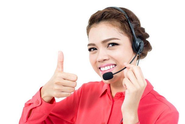 Young businesswoman  wearing microphone headset as an operator giving thumbs up - Photo, Image