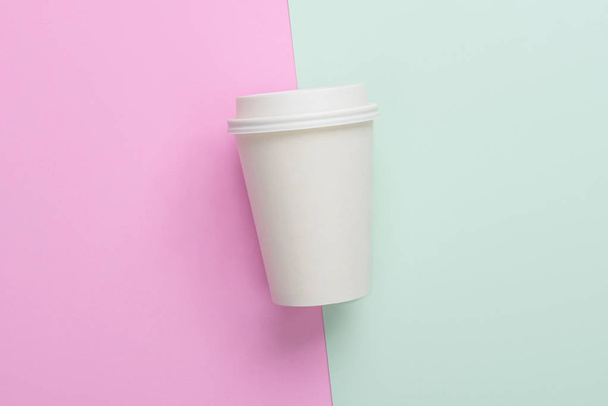 Φλιτζάνι καφέ μίας χρήσης takeaway (Βγάλτε) σε ανοιχτό μπλε και ροζ φόντο - Φωτογραφία, εικόνα