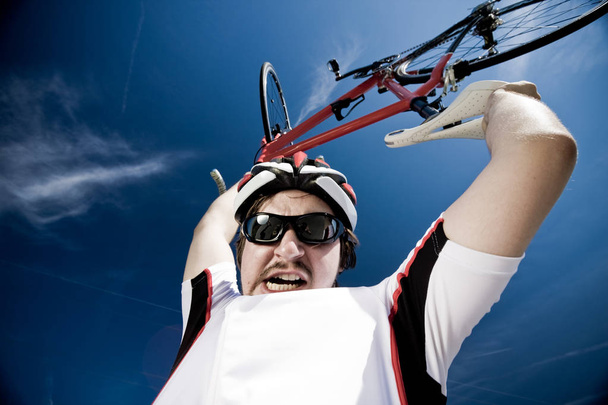 Homme portant un casque et soulevant le vélo dans l'air
 - Photo, image