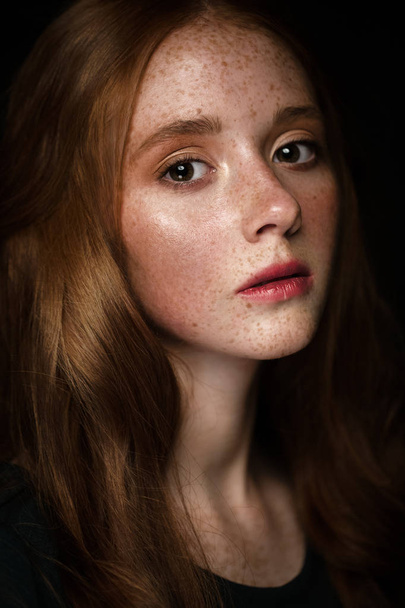 Beautiful Redhead girl with a perfectly curls hair and classic make-up. Beauty face. - Фото, изображение