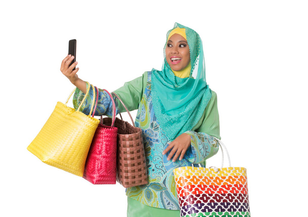 Mujer musulmana asiática con bolsas de mimbre tomando selfie.Isolated
 - Foto, Imagen