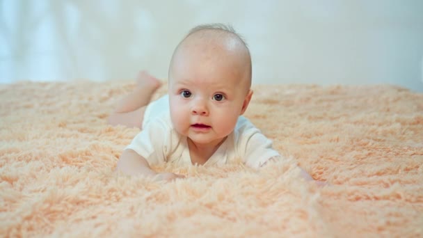 Baby liegt auf dem Bauch auf einem kuscheligen Teppich - Filmmaterial, Video