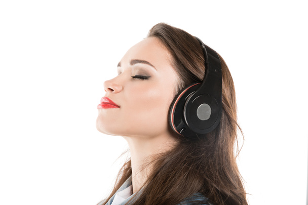 jonge vrouw luisteren muziek in hoofdtelefoon - Foto, afbeelding