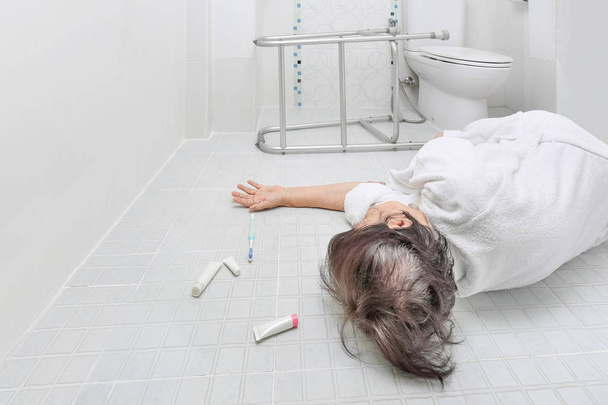 oudere vrouw vallen in de badkamer omdat gladde oppervlakken - Foto, afbeelding
