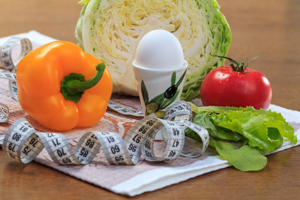 Poivre, oeuf, chou, tomate, salade et règle sur la table
 - Photo, image