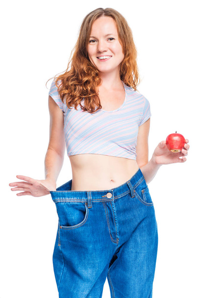Woman with an apple in her hand supports a large size of old jea - Foto, afbeelding
