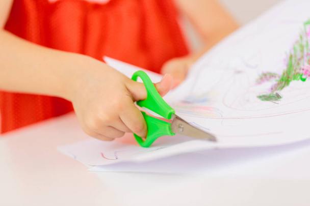 Ruce dítěte řezání papíru s nůžkami - Fotografie, Obrázek