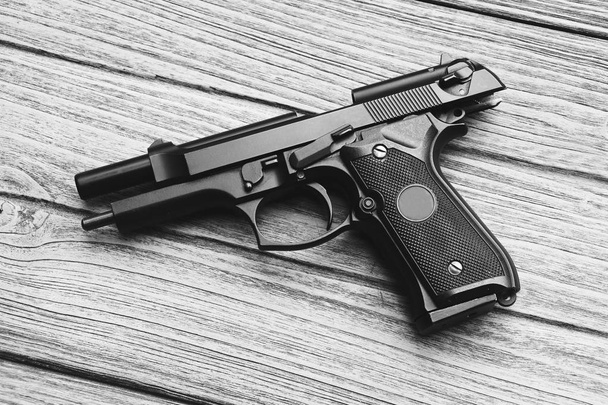 Série d'armes. Arme de poing moderne de l'armée américaine M9 gros plan sur fond en bois, 45 pistolet. Des armes. (noir et blanc
) - Photo, image